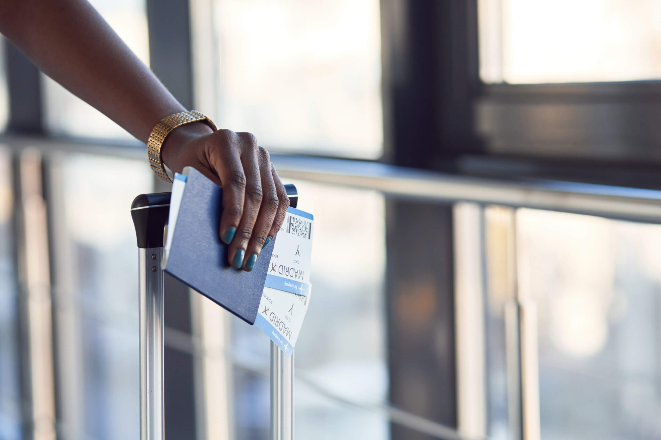 Young african american female passanger in casual clothes is in airport with tickets.